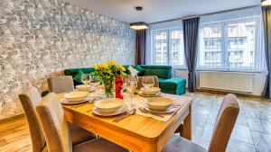 een eetkamer met een tafel en een groene bank bij Apartament PO PRACY z SAUNĄ - 5D Apartamenty in Świeradów-Zdrój