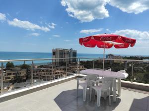 a table and chairs on a balcony with a view of the ocean at Ivtour Apartments in Yalta complex in Golden Sands