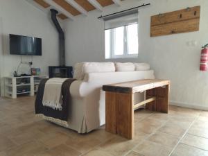 a living room with a couch and a table at Monte da Rocha 3 Marias in São Bartolomeu da Serra