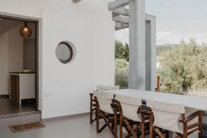 a dining room with a white table and chairs at Lagoon View villa in Lefkada Town