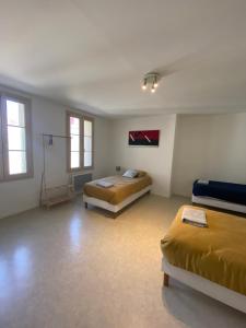Habitación grande con 2 camas y mesa. en L'appartement ZEN LOC 2, en Bray-sur-Seine