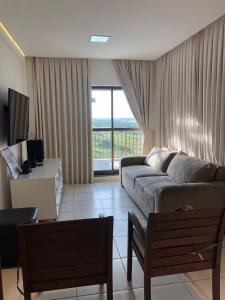 ein Wohnzimmer mit Couch und großem Fenster in der Unterkunft Cobertura Duplex Beverly Hills in Aquiraz