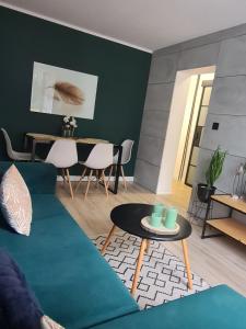 uma sala de estar com um sofá verde e uma mesa em Green Loft Apartament em Biała Podlaska