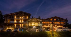 a building with cars parked in front of it at night at Chalet Hôtel & Spa Le Collet in Xonrupt-Longemer