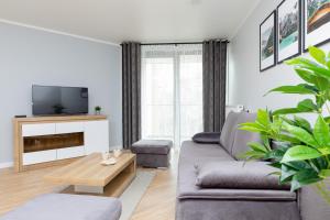 a living room with a couch and a tv at Lux Apartament z Widokiem na MORZE - Mazowiecka 213 by Renters in Pobierowo