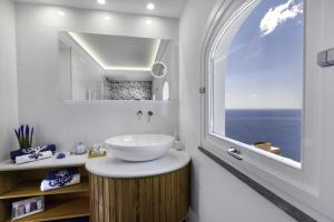 a bathroom with a sink and a large window at Estate4home - Villa Settemari Scrigno in Positano