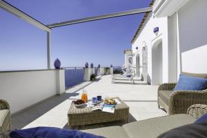 Un patio con sillas y una mesa en el balcón. en Estate4home - Villa Settemari Scrigno en Positano