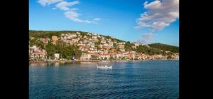 a small boat in the water in front of a town at AFISSOS-DREAM 3STUDIOS in Afissos
