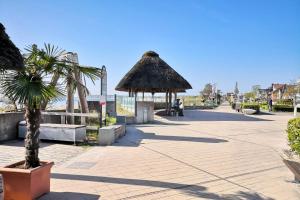 a pavilion with a palm tree on a sidewalk at Ostseecamp Lübecker Bucht Ferienhaus "JU-LI" mit kostenlosen Saunazugang in Scharbeutz