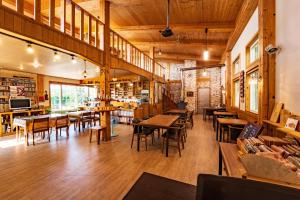 a restaurant with wooden floors and tables and chairs at Healing Camp Yesone in Gangneung