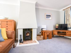 a living room with a couch and a fireplace at Seagull Cottage in Lyme Regis