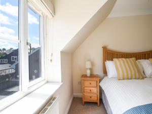 a bedroom with a bed and a large window at Seagull Cottage in Lyme Regis