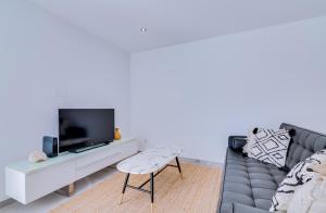 a living room with a couch and a tv at AL - Barracuda Village in Vilamoura