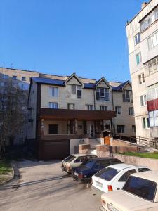 a building with cars parked in a parking lot at Hotel Pivdennyi in Oleksandriya