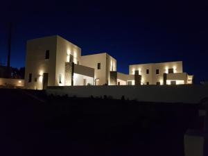 un bâtiment la nuit avec ses lumières allumées dans l'établissement myLithos Suites, à Monolithos