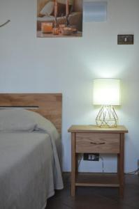 una camera con letto e tavolo con lampada di il Cigno Reale-Green-Rooms Leasing Touristic Ragusa a Chiaramonte Gulfi