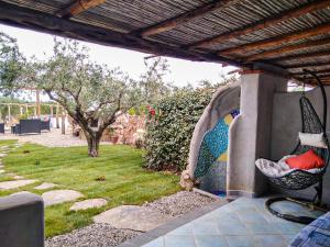 a patio with a swing and a yard at Cuccuru Relax - B IUN Q9882 in Orosei