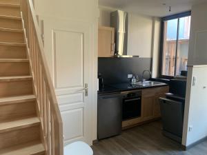 a kitchen with a staircase and a sink and a stove at la grange à Emile in Dambach-la-Ville