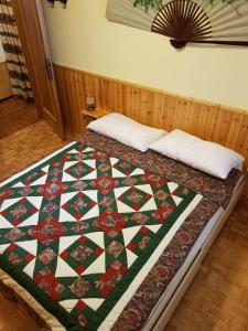 a quilt on a bed in a room at Appartamento Borgo Rio Muri in Auronzo di Cadore