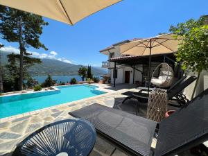 a patio with a table and chairs next to a pool at Villa Fortezza in Ohrid
