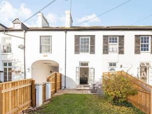 an exterior view of a white house with a wooden fence at Lovely Heather House 1 double 6 single beds in Torquay