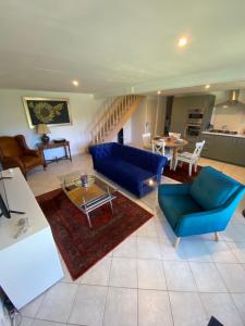 a living room with blue chairs and a table at Maison de Montgibaud in Montgibaud