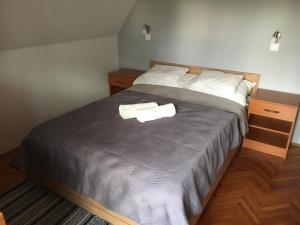 a bedroom with a bed with two towels on it at Nana Apartmanház in Hajdúszoboszló