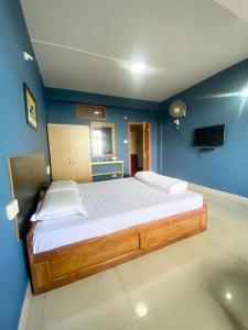 1 dormitorio con 1 cama grande en una pared azul en Chief Guest House, en Āīzawl