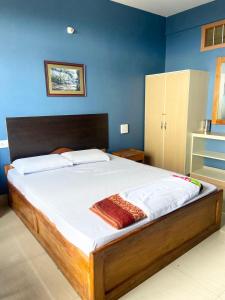 1 dormitorio con 1 cama grande y pared azul en Chief Guest House, en Āīzawl