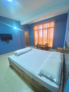 a bedroom with a large bed and a tv at Chief Guest House in Āīzawl