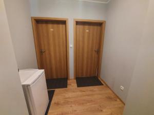pasillo con 2 puertas de madera en una habitación en Pokoje Gościnne Maczek en Sztutowo