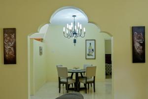 a dining room with a table and chairs and a chandelier at Champagne Villa in Whitehouse