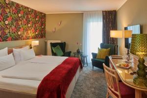 une chambre d'hôtel avec un lit, une table et des chaises dans l'établissement Parkhotel Weiskirchen, à Weiskirchen