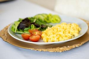 a plate of food with tomatoes and vegetables on a table at Hotel MAXPLAZA in Trnava