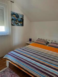 a bed in a bedroom with a painting on the wall at Apartments Maria in Ivanica
