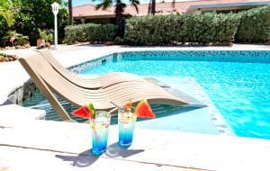 two drinks on a table next to a swimming pool at Kas Amigu accomodations in Willibrordus