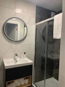 ein Bad mit einem Waschbecken und einer Dusche mit einem Spiegel in der Unterkunft 13 Eyre Square Lane in Galway