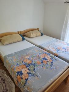 two beds sitting next to each other in a bedroom at Apartments Maria in Ivanica