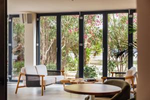 a living room with large windows and tables and chairs at Pacha Hotel in Ibiza Town