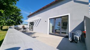 een wit gebouw met een patio met een tafel en stoelen bij Agroturystyka Rybno in Rybno