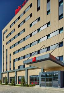 an office building with a red hotel sign on it at ibis Ankara Airport Hotel in Ankara