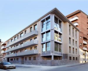 un edificio de apartamentos con un coche aparcado delante de él en Apartaments Terraza Figueres, en Figueres