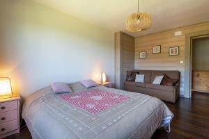 sypialnia z dużym łóżkiem i kanapą w obiekcie La Vallée de Ventron w mieście Ventron