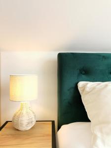 lampa na drewnianym stole obok łóżka w obiekcie Piaski i Trawy w Łebie