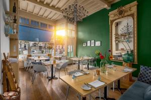 een restaurant met tafels en stoelen en een groene muur bij Nr 19 Bed and Bubbels in Middelburg