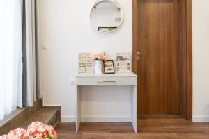 une petite table blanche avec un miroir et une porte dans l'établissement Sevastopol apartments Varna, à Varna 94 autres photos