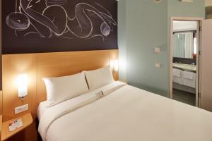 a bedroom with a large white bed and a mirror at ibis Ankara Airport Hotel in Ankara