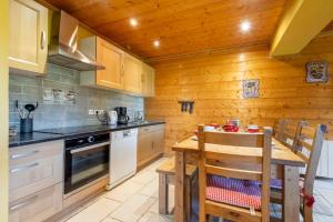 a kitchen with a table and a wooden wall at Les Pistes de Ventron in Ventron