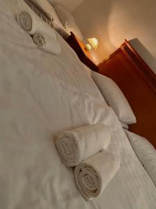 a white bed with towels on top of it at Füredi Panzió in Tiszafüred +3 photos