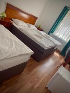 two twin beds in a bedroom with a window at Füredi Panzió in Tiszafüred